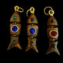 Wooden fish-shaped keychains with colored stones on a display tray.