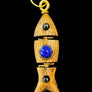 Wooden pendant with blue stone and gold accents on a textured black background