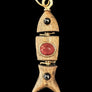 Decorative pendant with a red stone on a textured gray background