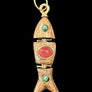Wooden fish-shaped pendant with gold accents and embedded stones on a textured gray background