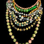 Stack of multicolored beaded necklaces on a mannequin with a neutral background