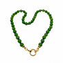 Green beaded necklace with a purple pendant on a white background